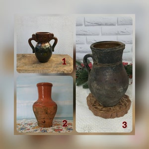 Pode incluir: Três vasos de cerâmica em estilos e cores diferentes. O primeiro vaso é um vaso pequeno, verde e marrom com duas alças. O segundo vaso é um vaso alto, laranja com um corpo arredondado. O terceiro vaso é um vaso grande, marrom escuro com uma boca larga e uma alça.
