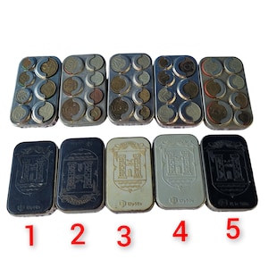 May include: Five vintage metal coin holders with a design of a castle on the front. The holders are in different colors: black, silver, and gold. The holders are numbered 1 through 5.