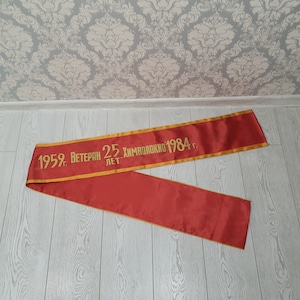 May include: Red satin ribbon with gold lettering that reads "1959. Veteran 25...  хмволочно 1984 г."