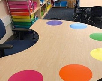 May include: A light wood table with a paint palette design. The table has eight colorful circles in shades of purple, blue, green, yellow, orange, red, and pink.