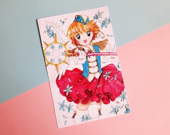 May include: A colourful illustration of a girl with blonde hair wearing a blue and red outfit and holding a golden wand with a star on top. She is surrounded by blue flowers and white feathers.