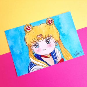 May include: Watercolor illustration of a character with blonde hair, blue eyes, and a red and blue outfit. The artwork is on a blue watercolor background, with a yellow and pink background. The character has a red heart-shaped necklace and a red bow.