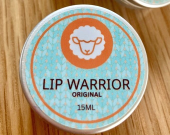 May include: Two small silver tins of lip balm with a blue and white patterned label. The label features a white sheep in an orange circle and the text "Lip Warrior Original 15ML".