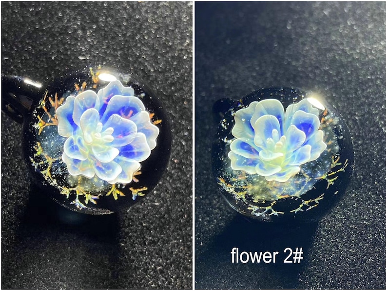 May include: Two round glass pendants with a blue and white flower design. The flower is encased in clear glass with a black background and gold accents. The text "flower 2#" is visible on one pendant.