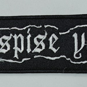 May include: Black embroidered patch with white lettering that reads "despise you" in a gothic font.