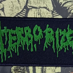 Op de afbeelding: Groen geborduurd patch met het woord "TERRORIZER" in een druipend, gotisch lettertype op een zwarte achtergrond.