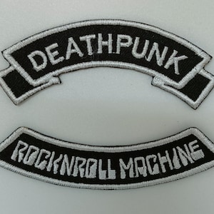 Könnte beinhalten: Zwei gestickte Patches in Schwarz und Weiß. Der obere Patch sagt "Deathpunk" in weißen Buchstaben. Der untere Patch sagt "Rock'n'roll Machine" in weißen Buchstaben.