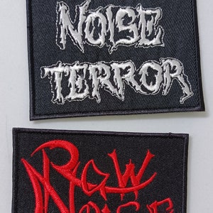May include: Two black fabric patches with embroidered text. The top patch has the text "EXTREME NOISE TERROR" in white. The bottom patch has the text "RAW NOISE" in red.