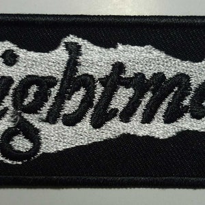 Könnte beinhalten: Schwarz-weißer gestickter Aufnäher mit dem Wort "Nightmare" in einer stilisierten Schrift.