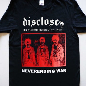 May include: Black t-shirt with a red and white graphic print of a band called "Disclose". The graphic features three people with mohawks and the text "The Nightmare Still Continues" and "Neverending War".