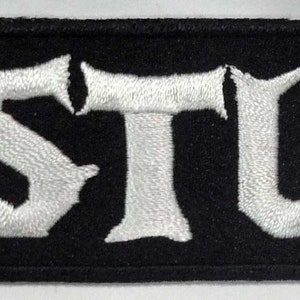 May include: Black embroidered patch with the word "GASTUNK" in white lettering.