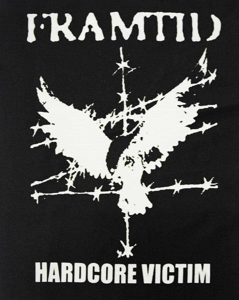 May include: Black graphic tee with the word "FRAMTID" at the top and "HARDCORE VICTIM" at the bottom. A white graphic of a bird with outstretched wings is in the center, with barbed wire and star-like shapes.