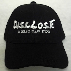 May include: Black baseball cap with white embroidered text that reads "DISCLOSE D-BEAT RAW PUNK".