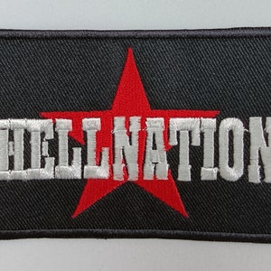 Puede incluir: Un parche bordado negro con una estrella roja y el texto "HELLNATION" en blanco.