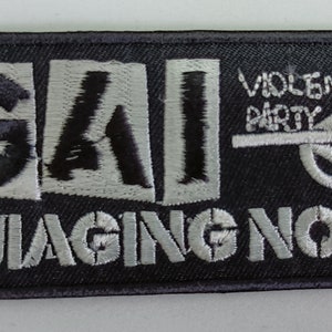 Puede incluir: Un parche bordado negro con el texto "GAI" en blanco, seguido del texto "VIOLENT PARTY" tachado con una línea blanca y un símbolo blanco, y el texto "DAMAGING NOISE" en blanco.