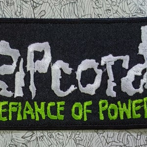 May include: A black embroidered patch with the white text "RIPCORD" and the green text "DEFIANCE OF POWER".