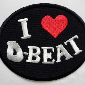 L'écusson brodé I Heart D-beat révèle le désarmement de la machine à décharge