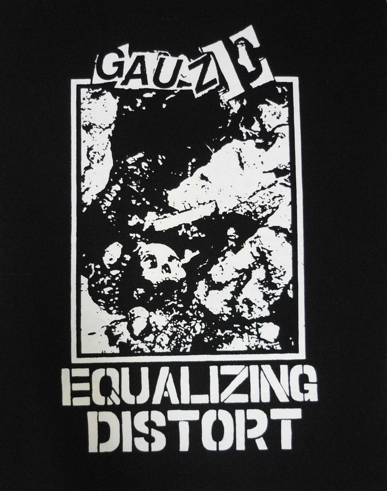May include: Black graphic tee with a white design. The design features the word "GAUZ" above a rectangular image of a skull and rock formation. Below the image, the words "EQUALIZING DISTORT" are printed in a stencil font.