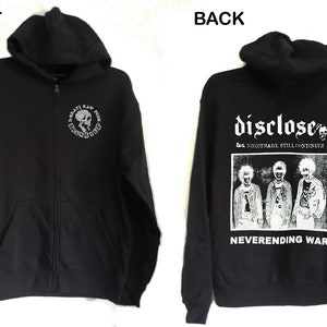May include: Black zip-up hoodie with a white skull and crossbones graphic on the front and a white graphic on the back that says "Disclose" with the text "The Nightmare Still Continues" and "Neverending War" underneath.