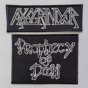 May include: Two black embroidered patches with white lettering. The top patch says "AXENAX", and the bottom patch says "Prophecy of Doom".