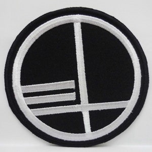 May include: A black and white embroidered patch with a circular design. The circle has a white border and a white line that divides the circle in half. There are three white lines across the bottom half of the circle.