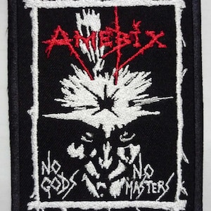 Puede incluir: Parche negro con borde bordado blanco. La palabra "Amebix" en rojo sobre un diseño blanco. El texto "No Gods No Masters" está en blanco debajo del diseño.