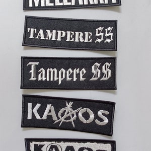 May include: Five black and white embroidered patches with white text. The patches read "Mellakka", "Tampere SS", "Tampere SS", "KaoS", and "KaoS".