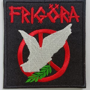 Peut inclure: Écusson brodé carré avec le mot "FRIKÖRA" en rouge, au-dessus d'une colombe blanche à l'intérieur d'un symbole de paix rouge. Une branche d'olivier verte est en dessous de la colombe. Fond noir.