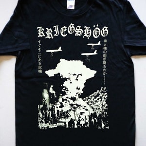 May include: Black t-shirt with a white graphic print of a scene of war with the text "KRIEGSHÖG" and Japanese text. The text reads "Blood and nuclear rain will fall... There is a crisis right there."