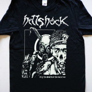 May include: Black t-shirt with a white graphic print of a skull wearing a gas mask and a helmet. The text "hellshock" and "Only the dead know the end of war" are printed in white.
