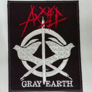 May include: Black and white embroidered patch with a peace sign and two doves. The text "AXE" is in red above the peace sign and "GRAY EARTH" is below the peace sign.