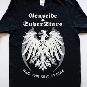 May include: Black t-shirt featuring a white graphic of an eagle with a pentagram, the text "Genocide Superstars" and the phrase "Hail the New Storm".