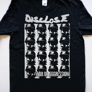 May include: Black t-shirt with a white graphic print of the band "DISCLOSE" and the text "WAR OF AGGRESSION". The graphic features a repeating pattern of soldiers' helmets.