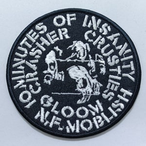 Peut inclure: Écusson brodé noir et blanc avec le texte "The Ministries of Insanity, Gloom, Crusher,  Selfish,  We Worship,  Crusty".