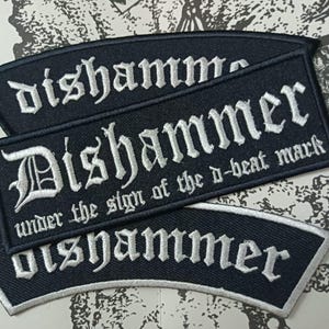 May include: Three black embroidered patches with white lettering. The top and bottom patches are curved with the text "dishammer". The center rectangular patch features the text "DISHAMMER" and "under the sign of the d-beat mark".