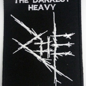 May include: Black and white embroidered patch with the text "The Darkest Heavy" and a stylized logo.