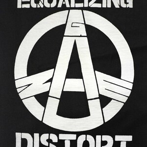 May include: Black t-shirt with a white graphic. The graphic features a large white circle with a stylized letter "A" inside, and the words "EQUALIZING" and "DISTORT" above and below the circle in a stencil font.