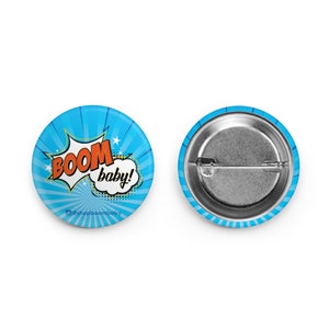 May include: A blue and orange button with the words "BOOM baby!" in a comic book style speech bubble. The button has a white background with a blue and white striped pattern.