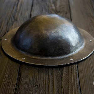 the shape of the umbon resembles the shape of a hat. the convex part has a hemispherical shape and flat sides, which lean against a horizontal surface, if you put umbon on a table or other surface.