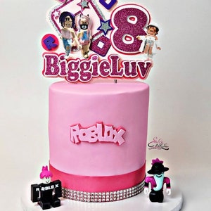 Peut inclure: G&acirc;teau sur le th&egrave;me de Roblox rose et blanc avec un dessus en fondant rose et blanc qui dit "BiggieLuv" et pr&eacute;sente un num&eacute;ro 8, des &eacute;toiles et des personnages de Roblox. Le g&acirc;teau est d&eacute;cor&eacute; d'un ruban rose et de strass.
