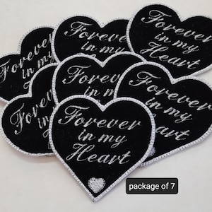 May include: A package of seven black felt heart-shaped patches with white embroidery that reads "Forever in my Heart".