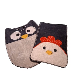 May include: Two denim-style fabric pot holders. One is shaped like an owl with large eyes, a yellow beak, and a grey quilted belly. The other is a chicken with a red comb and a white face with a floral pattern.