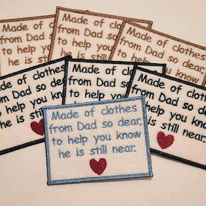 Peut inclure: Un ensemble de huit patchs brodés avec un fond blanc et du texte noir. Les patchs présentent un cœur rouge et le texte "Made of clothes from Dad so dear, to help you know he is still near."