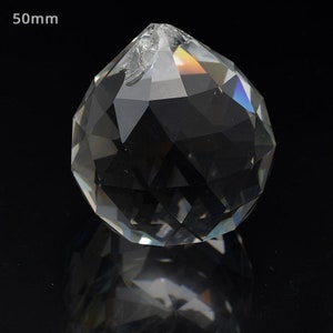 Peut inclure: Une boule de cristal transparente avec un design facett&eacute;. La boule mesure 50 mm de diam&egrave;tre.