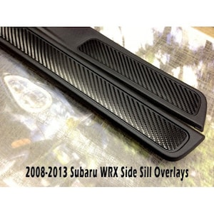 Könnte beinhalten: Schwarze Carbonfaser-Seitenschweller-Overlays für einen Subaru WRX 2008-2013. Die Overlays haben ein strukturiertes Muster und schützen die Seitenschweller des Fahrzeugs. Der Text "2008-2013 Subaru WRX Side Sill Overlays" ist sichtbar.