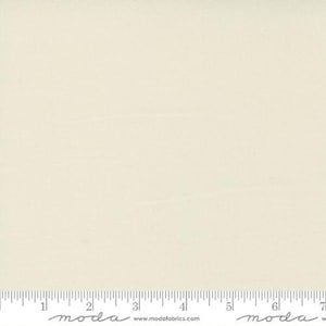 May include: A solid white fabric with a subtle texture. The fabric is shown with a ruler for scale.