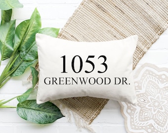 Puede incluir: Una almohada blanca con texto negro que dice "1053 GREENWOOD DR."
