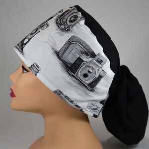 Può includere: Un cappello chirurgico con stampa di fotocamere vintage in bianco e nero. Il cappello ha il retro nero e un portacoda. Progettato per professionisti medici o chiunque necessiti di protezione per i capelli.