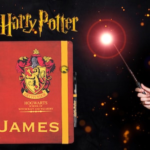 May include: A red notebook with a gold Gryffindor crest and the words "Hogwarts School of Witchcraft and Wizardry". The notebook is personalized with the name "JAMES".