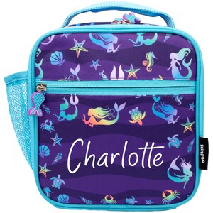 May include: A purple lunch bag with a mermaid and sea life pattern. The bag has a blue zipper and a mesh side pocket. The name "Charlotte" is printed on the front of the bag.